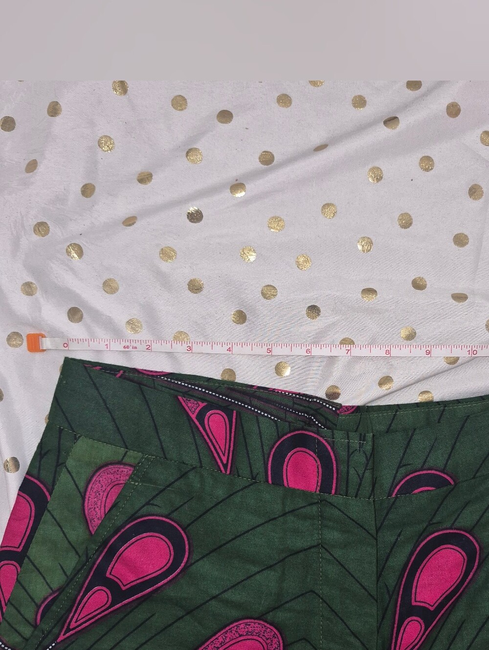 Queen E. Collection green trousers with a vibrant pink and black peacock feather